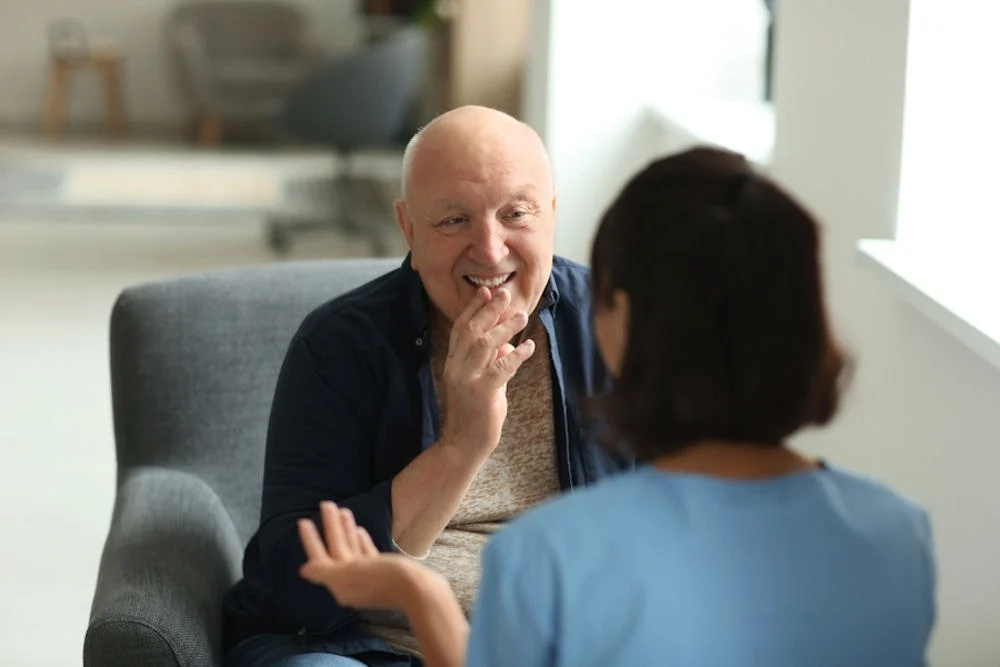 A therapist explaining the PTSD recovery stages to an elderly man A therapist explaining the PTSD recovery stages to an elderly man