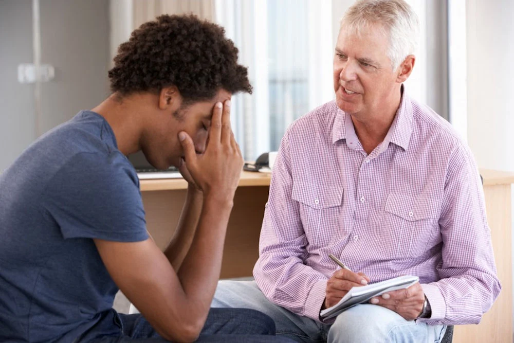 guy with social anxiety interviewed by therapist during therapy