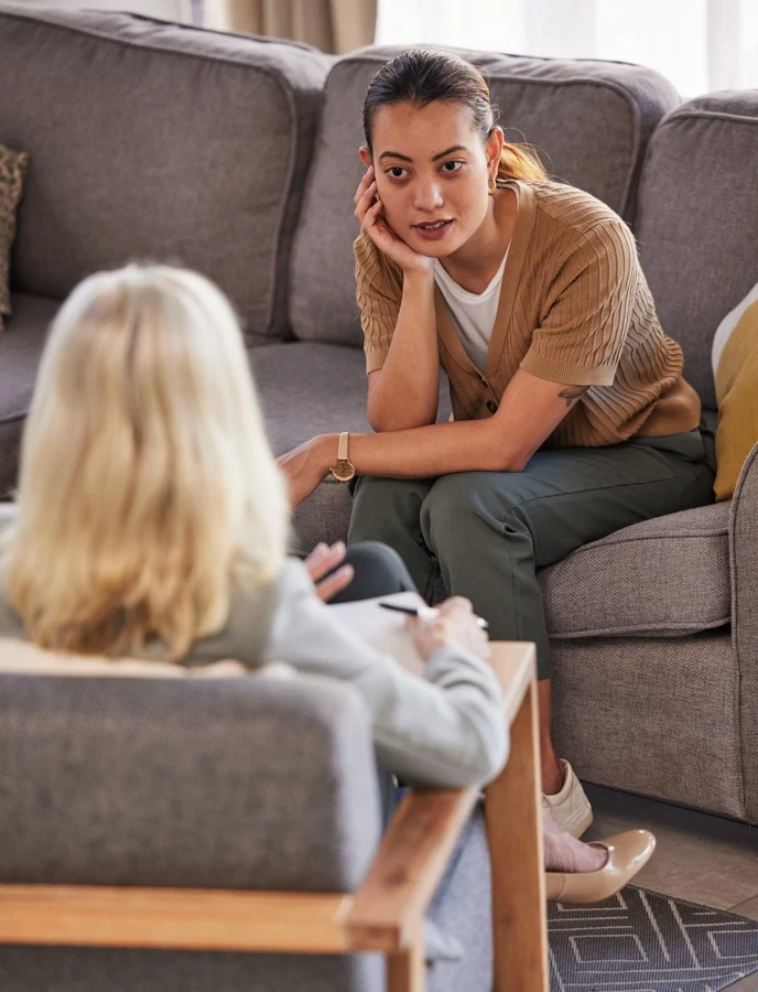 woman in CBT therapy session sitting on couch with therapist