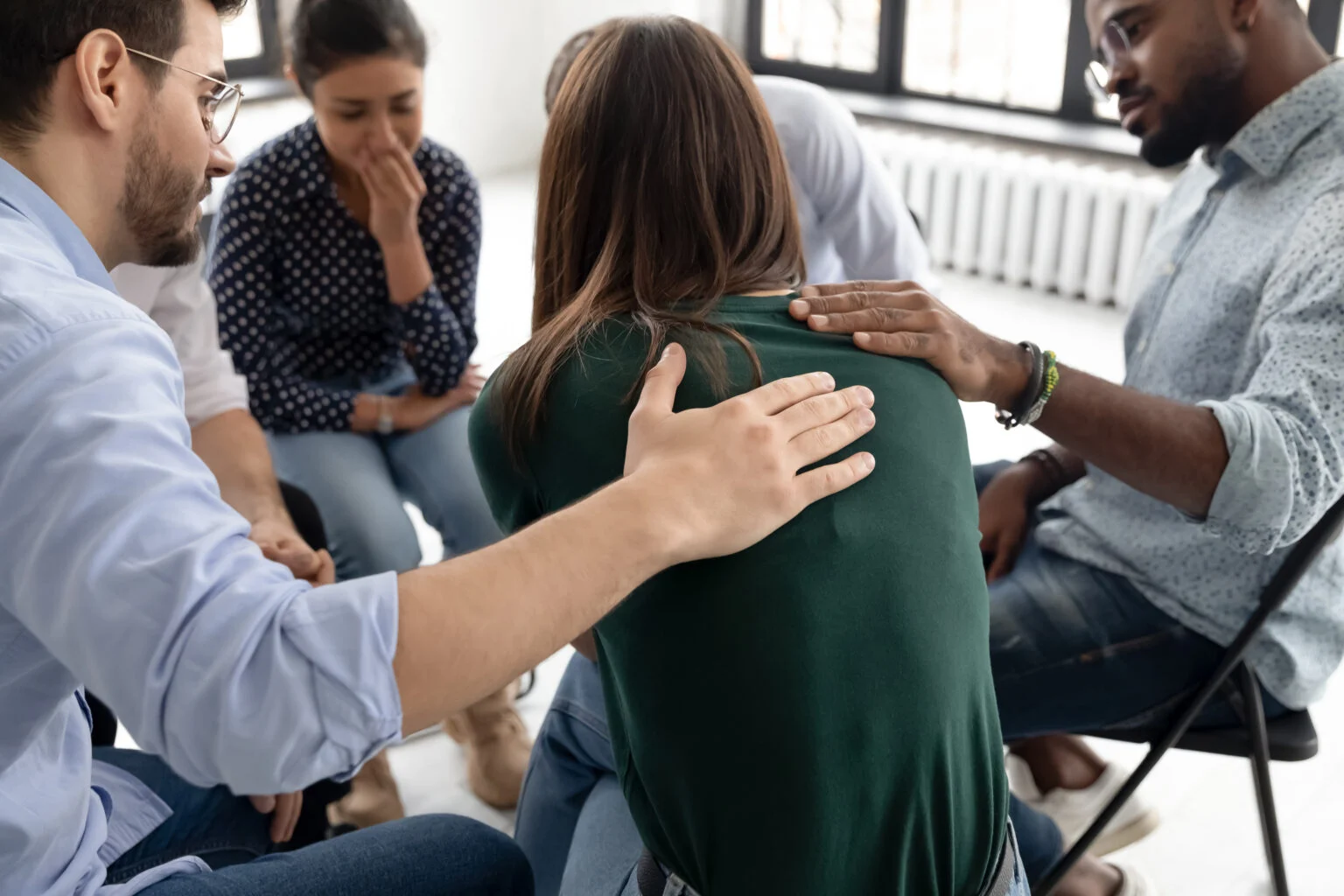 During group therapy session members supporting crying desperate girl group of people sitting together being discussed in ptsd therapy