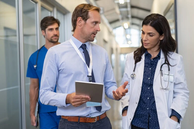 Doctor in a conversation with specialist doctor and specialists walking aisle discussing bipolar treatment program in orange county