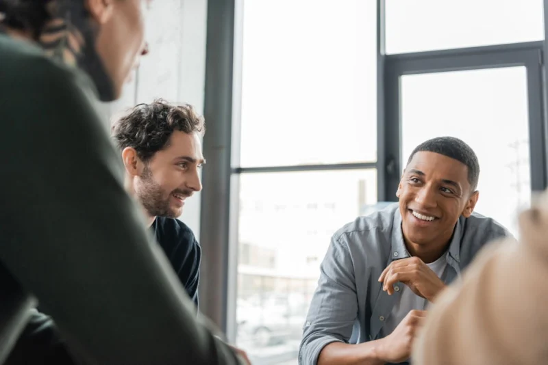 group of men smiling during cognitive behavioral therapy session