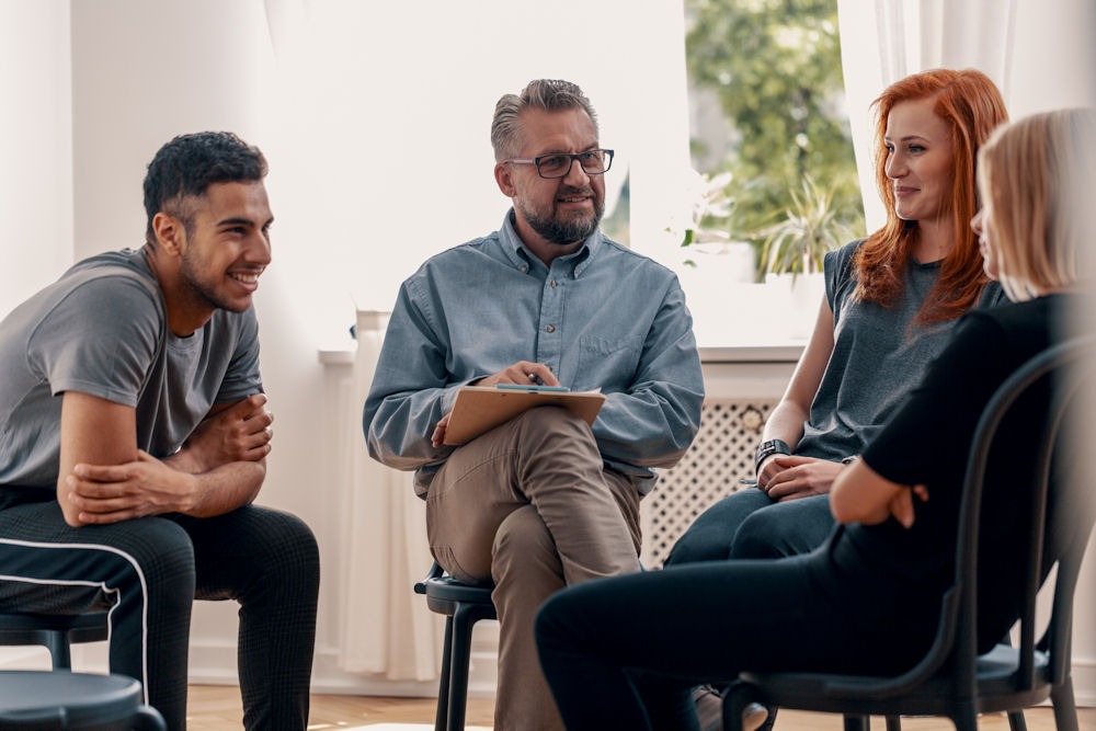 a group of people sitting in circle during therapy