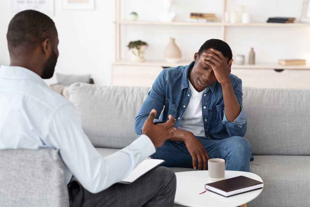 Therapist talking with man experiencing PTSD psychosis during counseling session